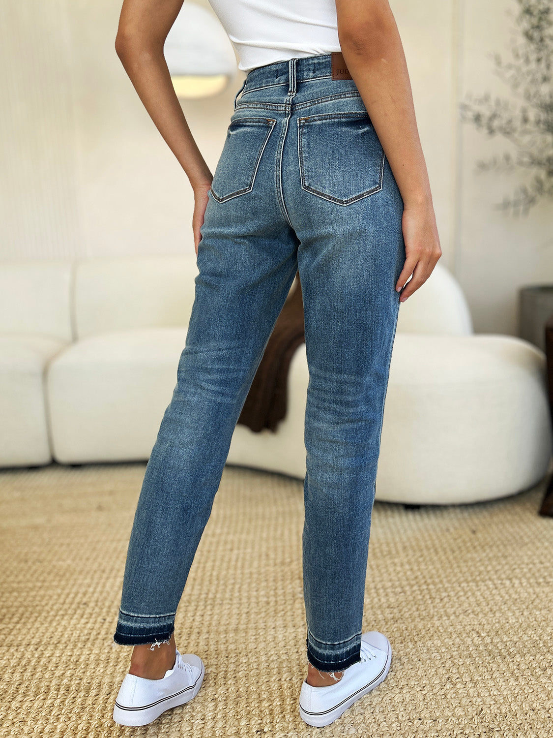 Judy Blue mid-rise jeans with magic release hem and classic fit, styled with white sneakers.