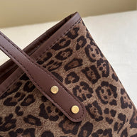 Leopard polyester tote bag with brown leather straps.