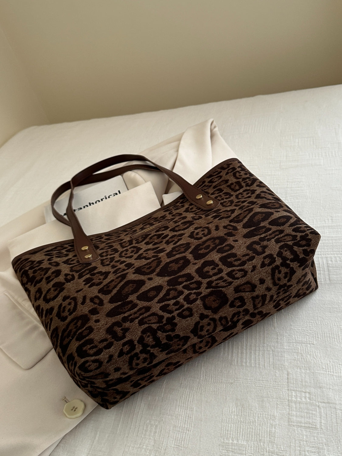 Leopard polyester tote bag with brown handles on a white background