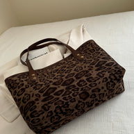 Leopard polyester tote bag with brown handles on a white background