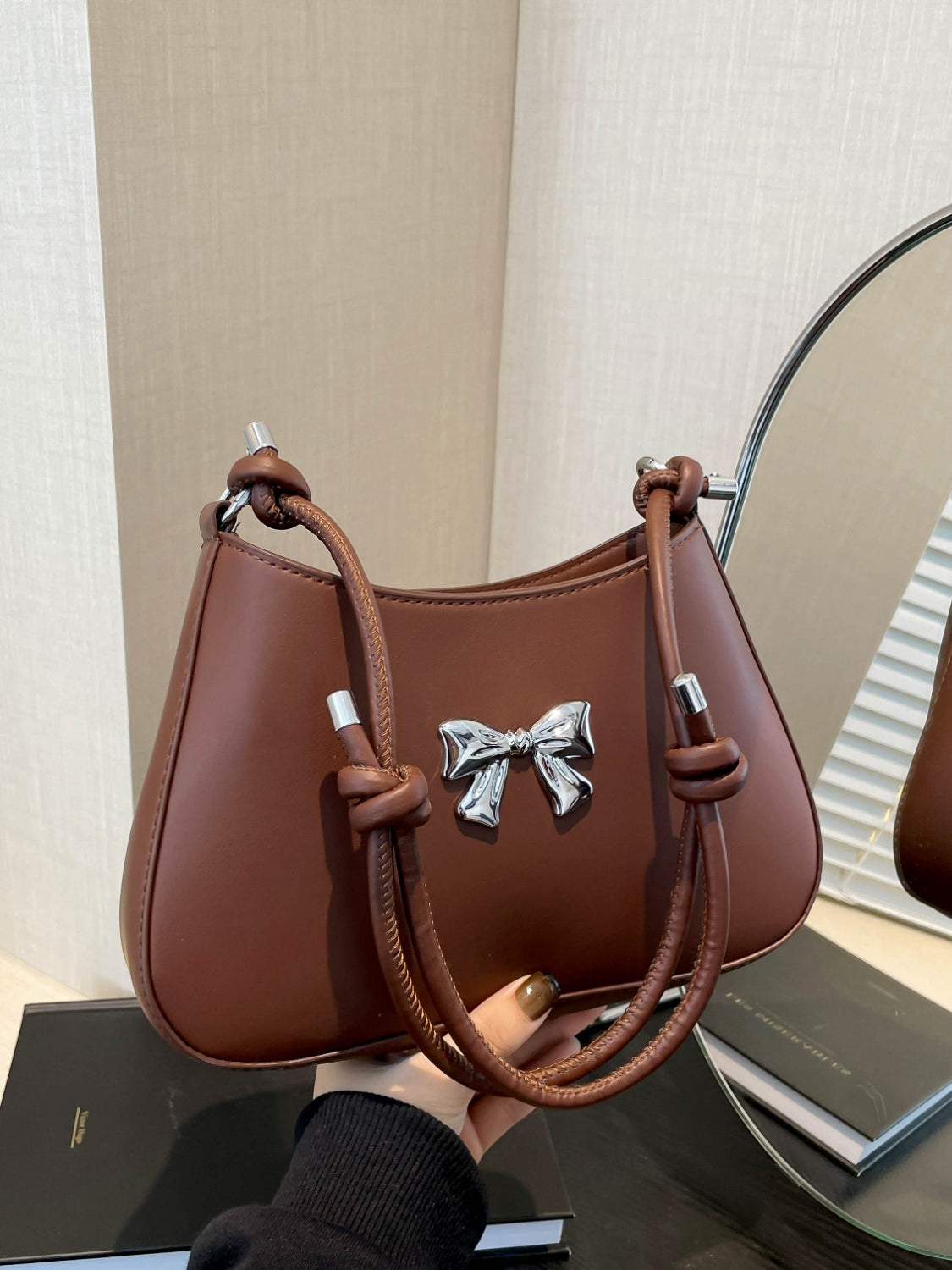 Small brown bow PU leather knotted strap handbag with silver bow detail.