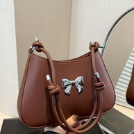 Small brown bow PU leather knotted strap handbag with silver bow detail.