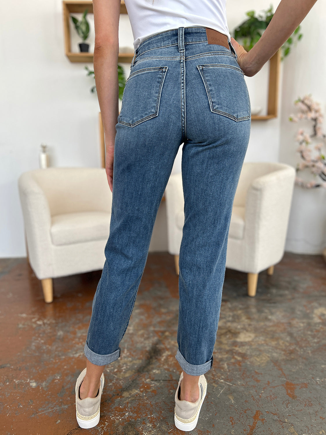 Judy Blue Full Size Cuffed Hem Slim Jeans in blue denim displayed from the back in a casual setting.