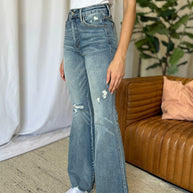 Judy Blue full size medium rise tummy control destroy flare jeans with distressed details, raw hem, and moderate stretch.