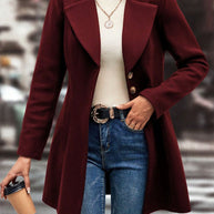 Collared neck button up long sleeve coat in burgundy, paired with a turtleneck and jeans.