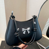 Small black PU leather handbag with knotted strap and bow detail.