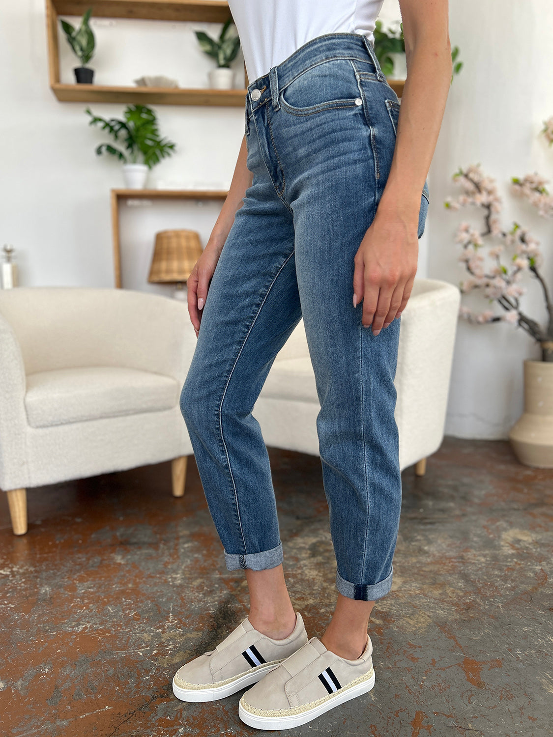 Judy Blue Full Size Cuffed Hem Slim Jeans styled with casual sneakers in a cozy room setting.