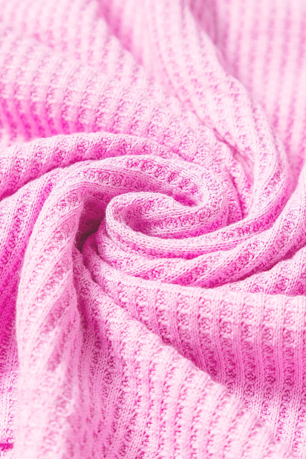 Pink waffle-knit fabric texture background.