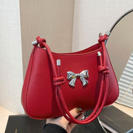 Small red bow PU leather knotted strap handbag with silver accents.