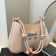 Small PU leather handbag with knotted strap and bow detail.