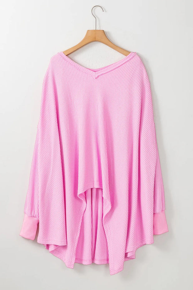 Pink waffle-knit V-neck long sleeve blouse on hanger.